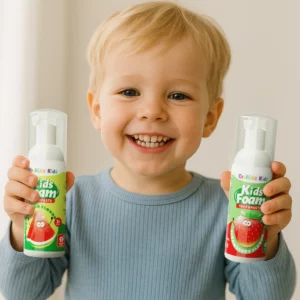 A smiling toddler (age 2–5) holding OralGos Tooth Mousse with both hands